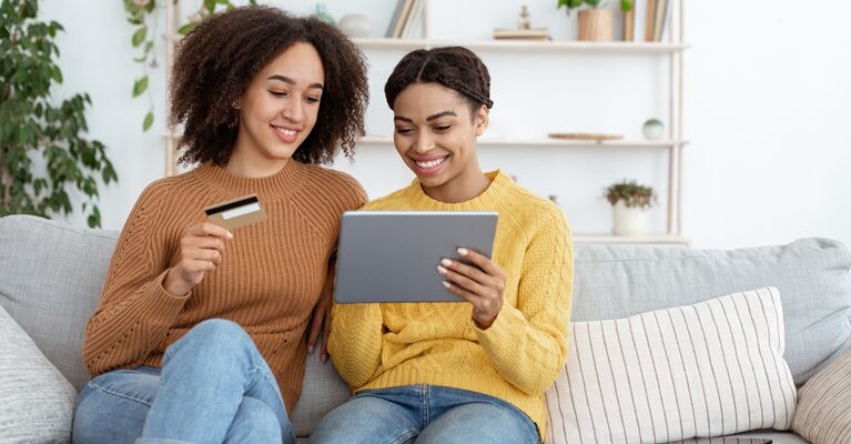 Two women making an online purchase using a credit card.