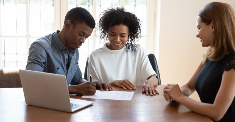 Man and woman signing documents.