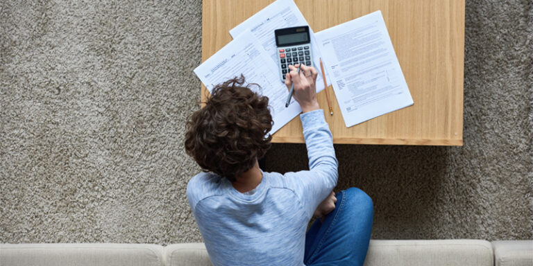 A man filling out forms and using a calculator.