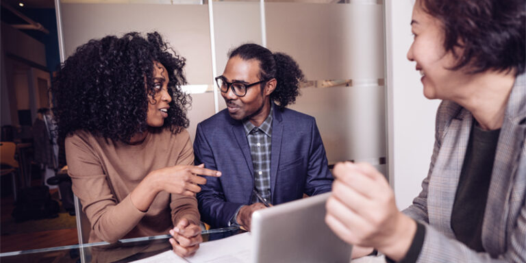 A couple talking with a businessperson.