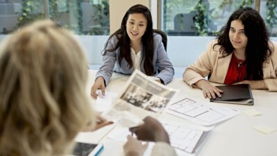 A real estate agent looking at commercial listings with two women.