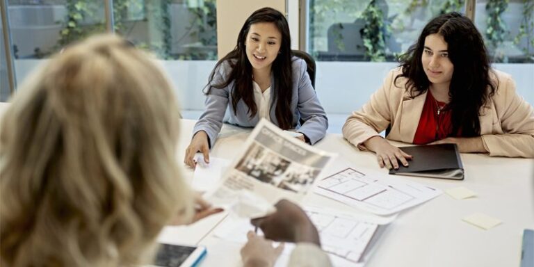 A real estate agent looking at commercial listings with two women.