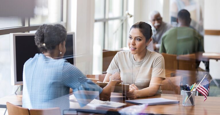 A woman speaking with a bank employee.