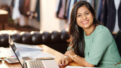 Woman smiling and using laptop.