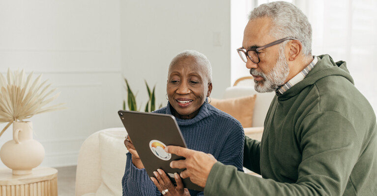 A couple looking at a tablet.