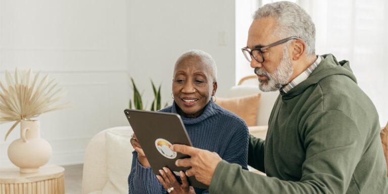 A couple looking at a tablet.