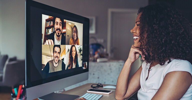 Woman videochatting with others on computer.