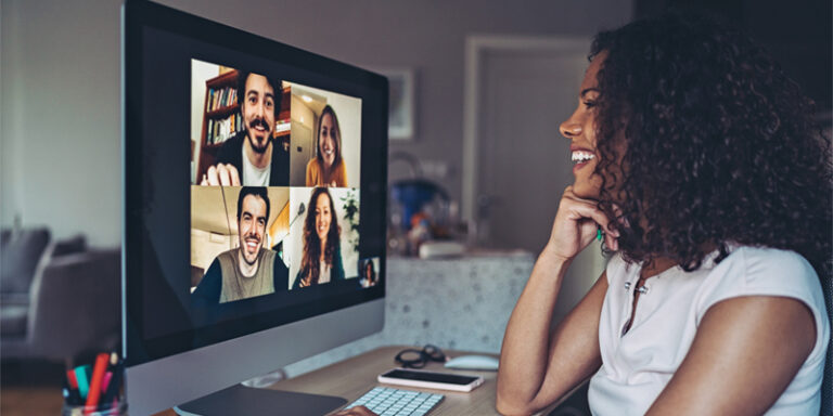 Woman videochatting with others on computer.