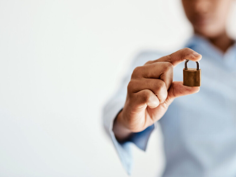 Man holding padlock to signify fraud protection.