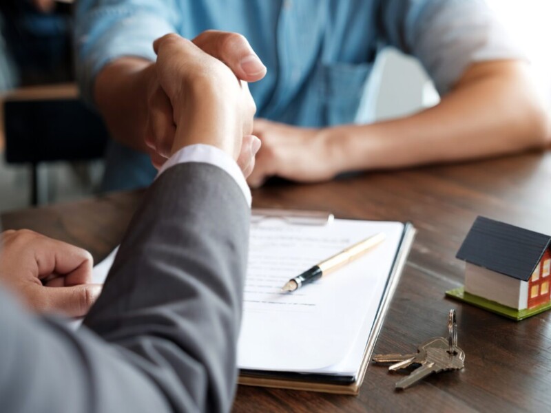 Real estate agent shaking hands with new homeowner.