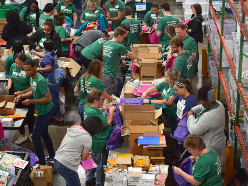 WSFS Associates volunteering, packing school supplies into backpacks.