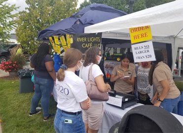 Customers visiting the River Lights Café tent at a local event.