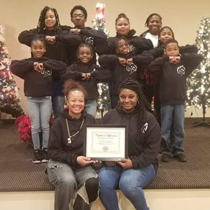 Teasa receiving certificate from cheerleading squad