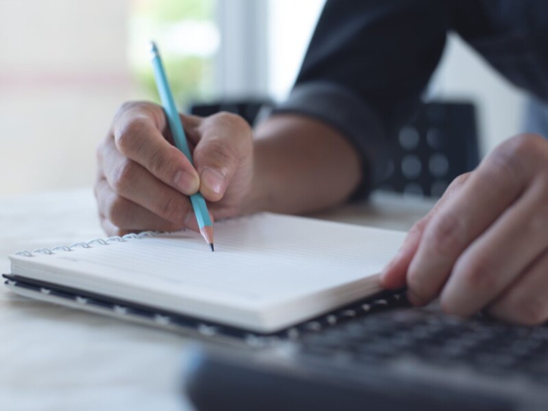 Person writing in notebook.