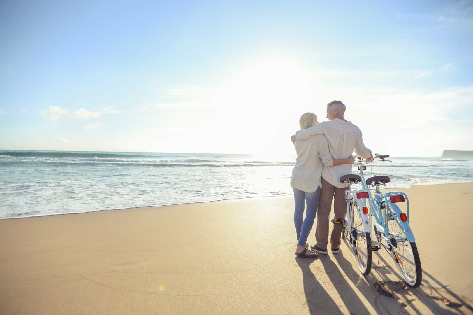 Earn More with WSFS Savings | A couple cycling on the beach.