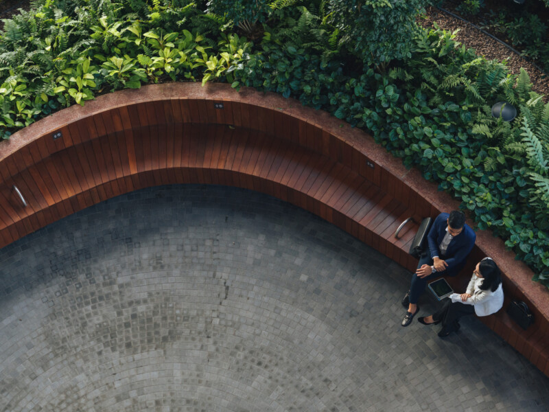 Two businesspeople on a curved bench.