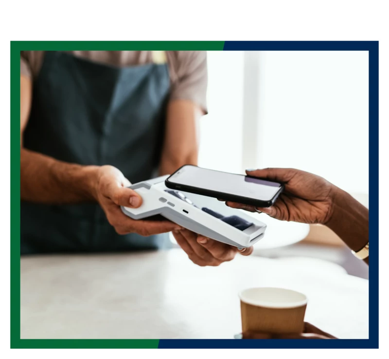 Cell phone being used to make a mobile payment with a handheld payment processor.