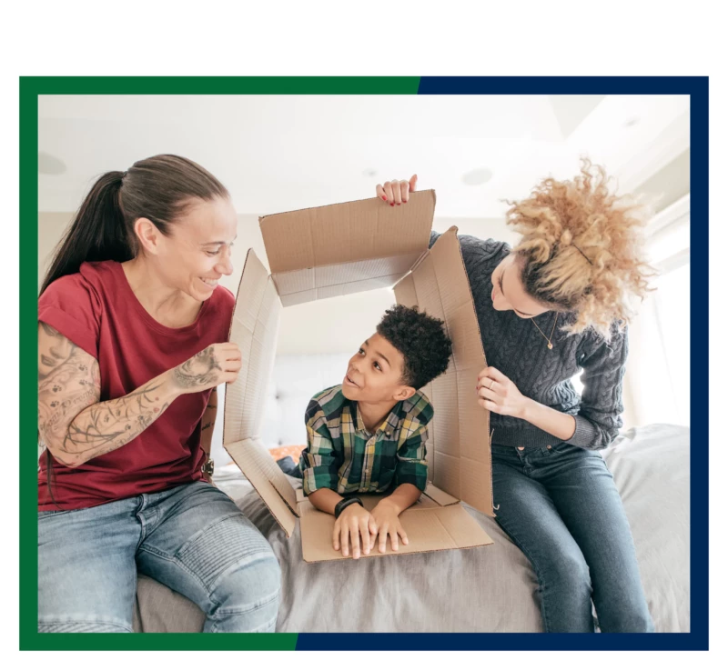 A couple playing with their child in a moving box.