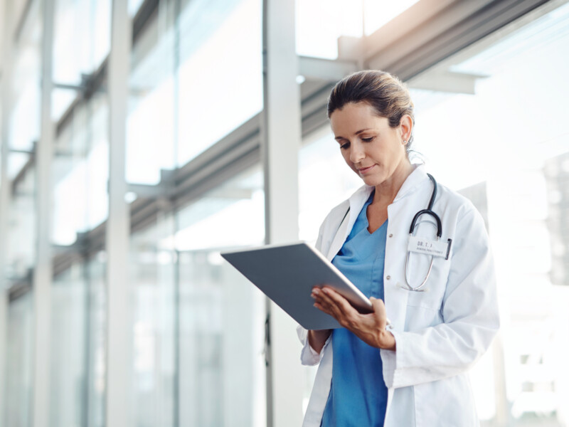 A doctor standing with a clipboard.