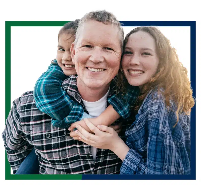 Family hugging and smiling at the beach.