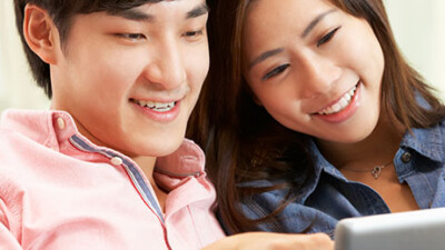 A couple looking at a tablet.