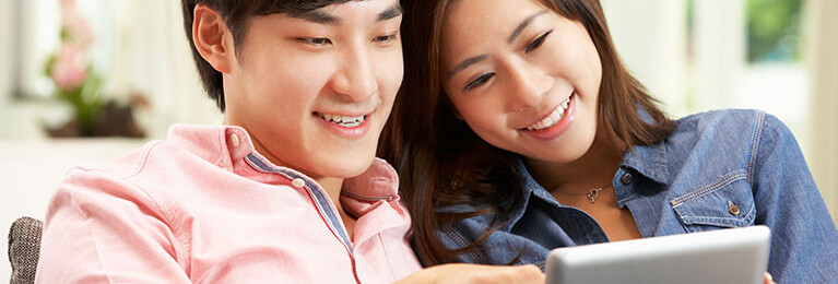 A couple looking at a tablet.