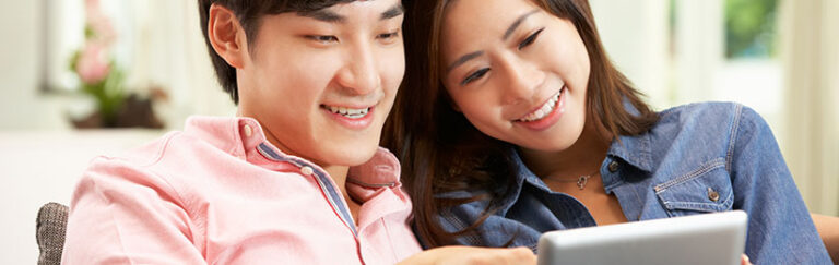 A couple looking at a tablet.