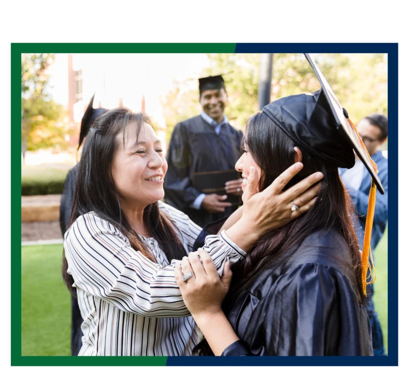 A mother embracing her graduate daughter.