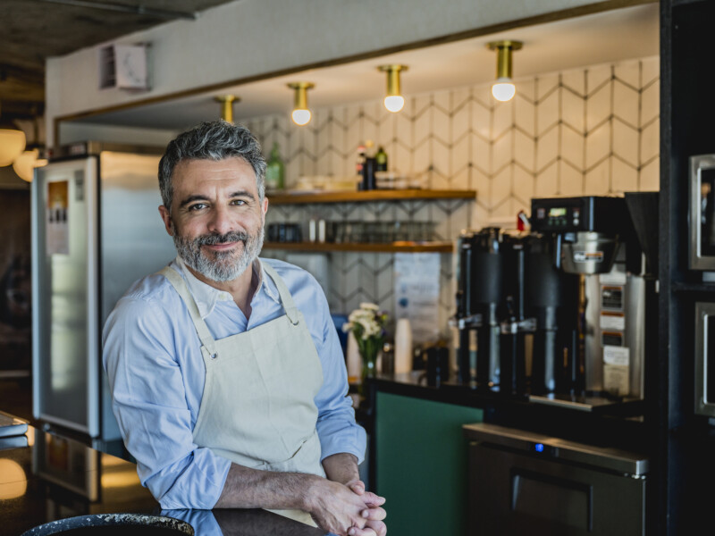 Male cafe owner in an apron.