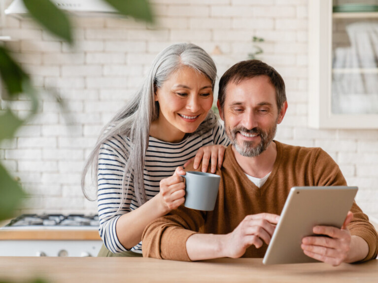 Man and woman using tablet to look at their checking account.