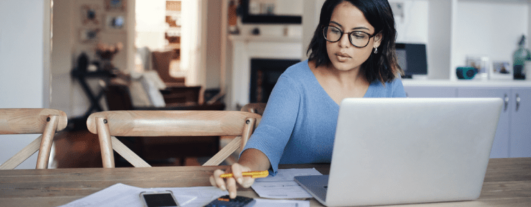 Woman using a calculator and a computer.