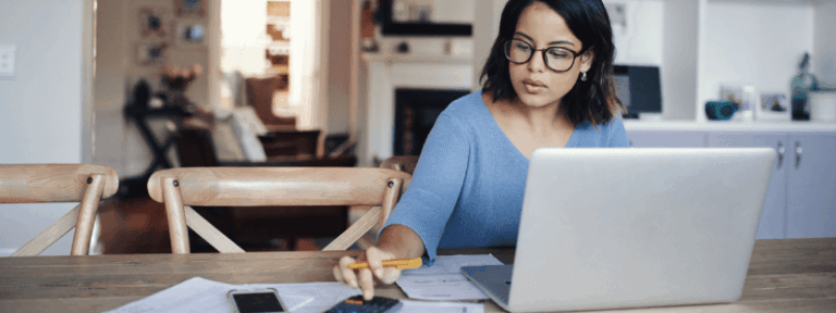 Woman using a calculator and a computer.