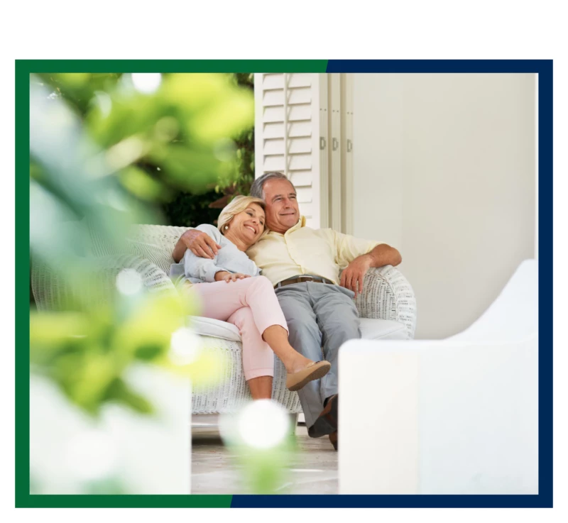 A couple sitting on their porch furniture.