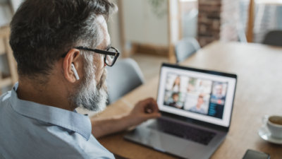 A man using his laptop to attend a video conference.