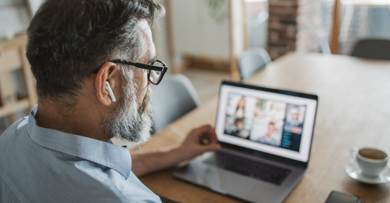 A man using his laptop to attend a video conference.