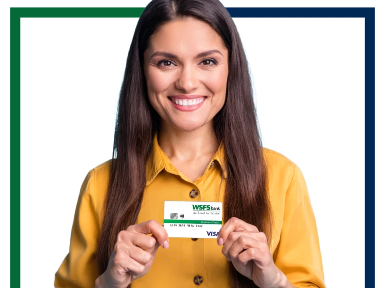 Woman holding WSFS business debit card.
