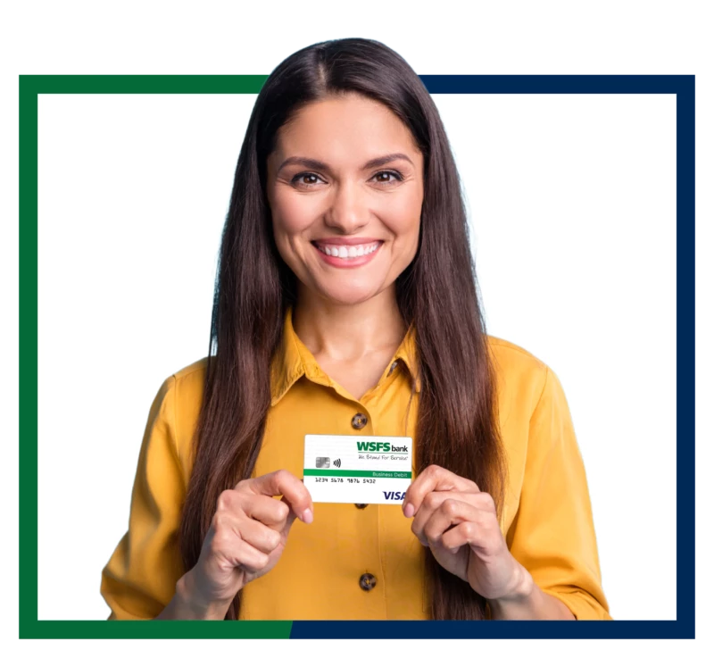 Woman holding WSFS business debit card.