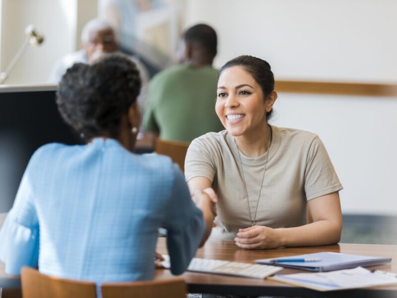 Woman shaking a businesswoman's hand.