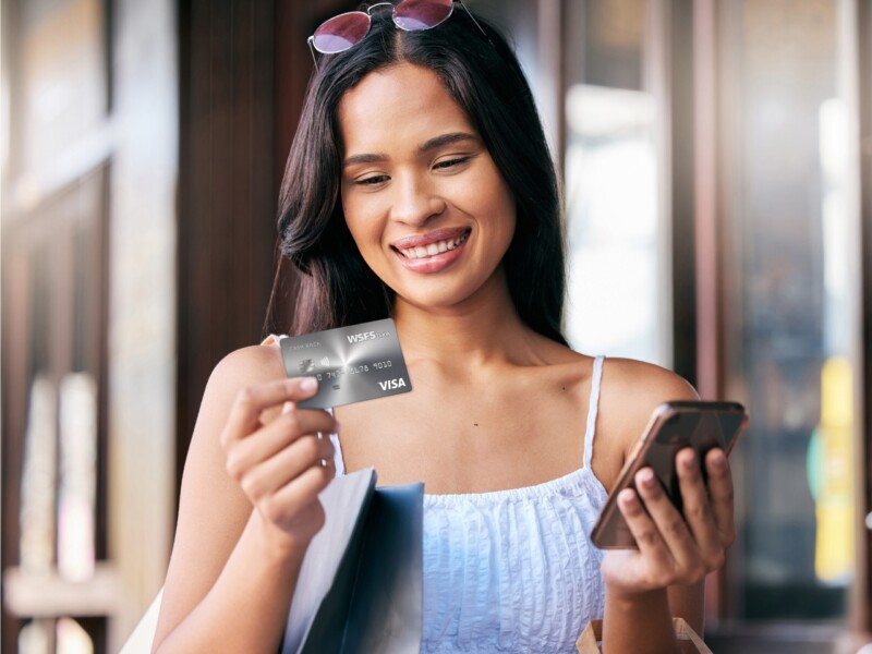 A woman holding the Cash Back Visa card.